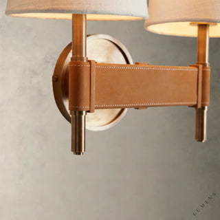 LUMENS LAMP Hastings 双头壁灯，采用做旧黄铜底座、棕色皮革缝线细节和白色亚麻灯罩，设计优雅。