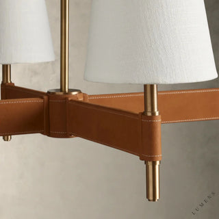 LUMENS LAMP Hastings 线性吊灯，采用做旧黄铜底座、棕色皮革缝线细节和白色亚麻灯罩，设计优雅。