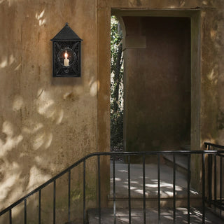 LUMENS LAMP Ripley 小型户外壁灯，采用午夜黑色锻铁饰面和透明种子玻璃，安装在质朴的户外墙面上。