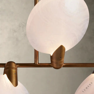 LUMENS LAMP Lyla 线性吊灯，采用手工吹制半透明玻璃圆盘和黄铜钢结构，展现出优雅的花瓣状轮廓。