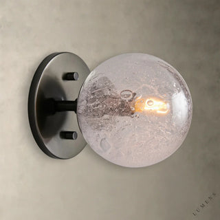 LUMENS LAMP Mandoza 壁灯，配有手工吹制气泡玻璃球和工业风格金属底座，散发温暖光芒。